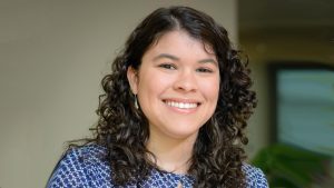 Person with black curly hair in blue shirt