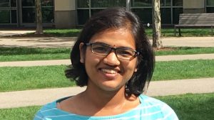 Person with black hair and glasses in front of Building 68 at MIT