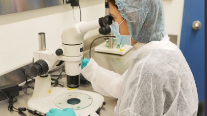 Person with hairnet at microscope