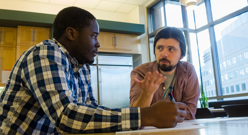 Two students at table talking