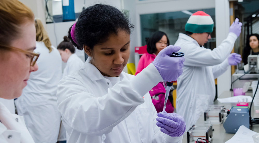 Student in lab coat pipetting