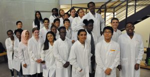 Students in white coats smiling