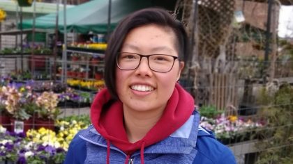 Person smiling by flowers